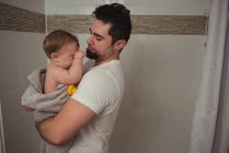Father holding baby son in bathroom at home — Stock Photo