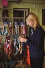 Жінка тримає комірці для собак в магазині в центрі догляду за собаками — стокове фото