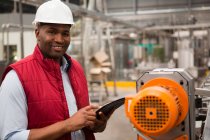 Zufriedener männlicher Mitarbeiter mit digitalem Tablet in Saftfabrik — Stockfoto