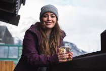 Portrait of woman in winter clothing holding beer glass — Stock Photo