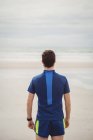 Вид ззаду спортсмена, що стоїть на пляжі — стокове фото