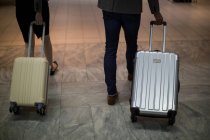 Деловые люди ходят с багажом в терминале аэропорта — стоковое фото