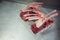 Gros plan sur la viande crue dans le bac d'emballage en plastique de l'usine de viande — Photo de stock