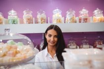 Портрет продавщицы, стоящей у стойки с турецкими сладостями в магазине — стоковое фото