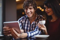 Пара с использованием цифровых во время кофе в ресторане — стоковое фото