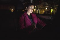 Mulher de negócios bonita usando tablet digital e telefone no carro — Fotografia de Stock