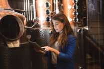 Mujer usando tableta digital en fábrica de cerveza - foto de stock