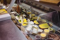 Salsicce e dessert al bancone del supermercato — Foto stock