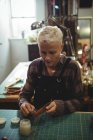 Atento artesão preparando cinto de couro na oficina — Fotografia de Stock