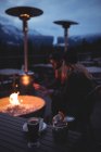 Пара сидить біля вогняної ями в сутінках взимку — стокове фото
