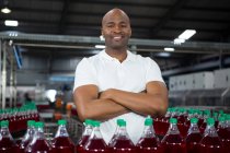 Portrait of confident male worker operating machine in cold drink factory — Stock Photo