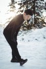 Homme étirant les jambes dans la forêt pendant l'hiver — Photo de stock