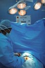 Female surgeon performing operation in operation theater at hospital — Stock Photo