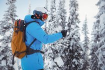 Skifahrer benutzt Handy auf schneebedeckten Bergen — Stockfoto