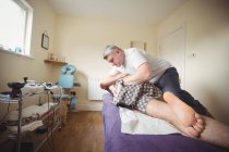 Physiotherapeut untersucht Rücken eines Patienten in Klinik — Stockfoto