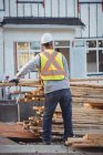 Bauarbeiter sortiert Holz auf Baustelle — Stockfoto