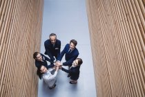 Vista aerea di uomini d'affari che impilano le mani insieme in ufficio — Foto stock