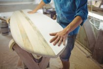 Mid section of man making surfboard in workshop — Stock Photo