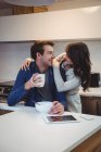 Casal interagindo uns com os outros enquanto toma café da manhã na cozinha em casa — Fotografia de Stock