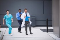 Médicos e enfermeiros correndo para emergência em instalações hospitalares — Fotografia de Stock