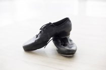 Pair of dancing shoes on wooden floor in dance studio — Stock Photo