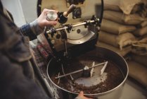 Milieu de section de l'homme broyage des grains de café dans la machine de broyage dans le café — Photo de stock