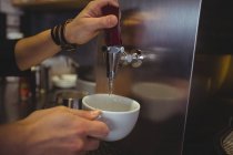 Kellnerin holt Wasser aus Wasserhahn im Café — Stockfoto