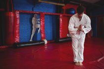 Giocatore di karate in posa di preghiera in palestra — Foto stock