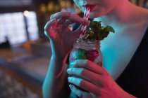 Сучасна жінка має коктейль в барі, обрізаний — стокове фото