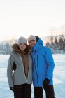 Portrait de couple souriant debout sur un paysage enneigé — Photo de stock