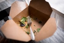 Ensalada sobrante en caja de comida en la cafetería - foto de stock
