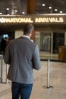 Rückansicht von Geschäftsmann mit digitalem Tablet im Wartebereich am Flughafen-Terminal — Stockfoto