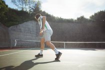Вид ззаду чоловіка, який грає в теніс на спортивному корті — стокове фото