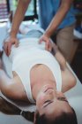 Чоловічий фізіотерапевт дає масаж талії пацієнтці в клініці — стокове фото