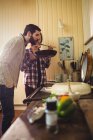 Hombre oliendo comida preparada por la mujer en la cocina - foto de stock