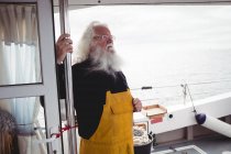 Nachdenklicher Fischer steht auf Fischerboot — Stockfoto