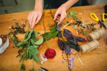 Imagen recortada de florista femenina preparando ramo de flores en su tienda de flores - foto de stock
