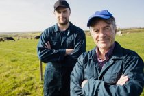 Портрет уверенных фермеров, стоящих на травянистом поле — стоковое фото