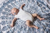 Bambino che dorme con manichino in bocca sul letto a casa — Foto stock