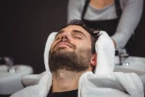 Hair stylist drying man hair with towel in salon — Stock Photo