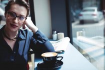 Retrato de una joven empresaria sentada en la cafetería - foto de stock