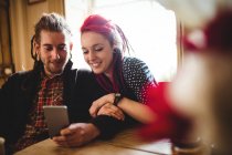Cheerful hipster couple using mobile phone at home — Stock Photo