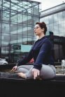 Comprimento total de empresária fazendo ioga contra prédio de escritórios — Fotografia de Stock