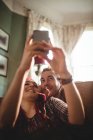 Glückliches Paar macht Selfie beim Entspannen auf dem Sofa zu Hause — Stockfoto