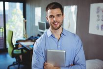 Portrait of male physiotherapist holding digital tablet in clinic — Stock Photo
