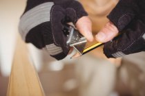 Cropped image of carpenter sharpening pencil — Stock Photo