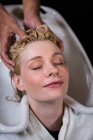 Frau lässt sich im Salon die Haare waschen — Stockfoto