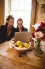 Junges Paar schaut auf Laptop auf Tisch im Haus — Stockfoto