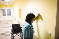 Infirmière déprimée debout dans le couloir — Photo de stock
