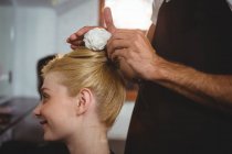 Hairdresser styling customers hair with spray in salon — Stock Photo